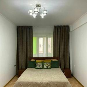 una camera da letto con un letto con cuscini verdi e gialli di Уютная квартира a Taraz