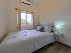 a bedroom with a white bed and a window at San Pablo Villas in San Pedro
