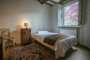 1 dormitorio con cama y ventana en Albergo La Pietra, en Roccalbegna