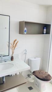 a white bathroom with a sink and a toilet at Rio Stay Suíte in Rio de Janeiro