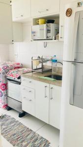 a kitchen with white cabinets and a refrigerator at Rio Stay Suíte in Rio de Janeiro