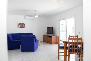 een woonkamer met een blauwe bank en een tafel bij VILLA ADELAIDA in L'Eucaliptus