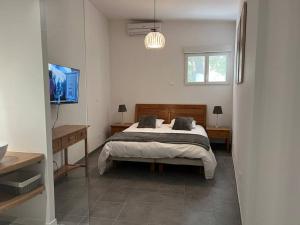 sypialnia z łóżkiem, dwoma stołami i telewizorem w obiekcie T3 avec spa, hyper centre, port w mieście Porto-Vecchio