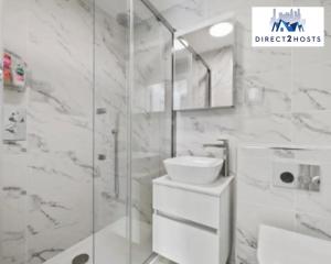 bagno bianco con lavandino e doccia di Three Bedroom Beautiful & Comfy Acton Gem Apartment by Direct2hosts With King Beds & Free Parking! a Londra