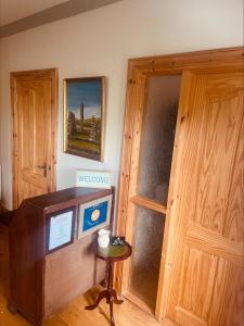 a room with a television and a wooden door at Maghera House in Enniskillen