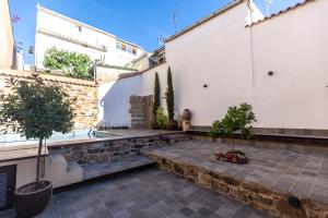 un patio con plantas y un fregadero en un edificio en Apartamentos Turísticos DE LA BERNARDA, en Cáceres