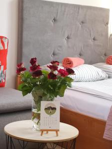 a table with a vase of flowers on a bed at STARE MIASTO in Olsztyn