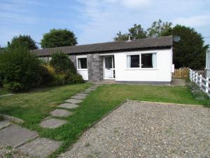 a small white house with a grass yard at Ty Nain, Newport, Pembrokeshire in Newport Pembrokeshire