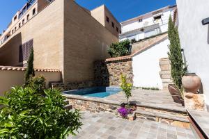 una casa con piscina en un patio en Apartamentos Turísticos DE LA BERNARDA, en Cáceres