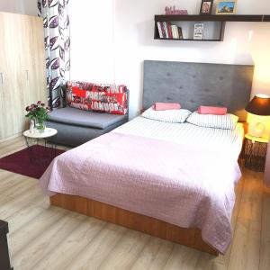 a bedroom with a large bed and a couch at STARE MIASTO in Olsztyn