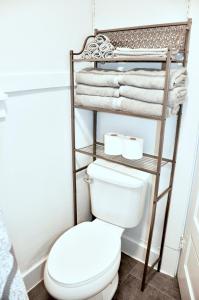 a bathroom with a toilet and towels on a shelf at Downtown 1 Bedroom Charmer - Walk, Bike, Enjoy!! in Rapid City
