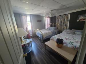 a bedroom with two beds and a table with a lamp at Cool Vibes Cottage in Renovo