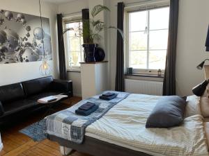 um quarto com uma cama e um sofá preto em Sveriges minsta Hotell! Hôtel Gruyère em Landskrona