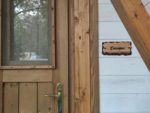 una puerta de madera con un cartel en el lateral de una casa en Orme nel parco - Villaggio Grechi, en Tirivolo