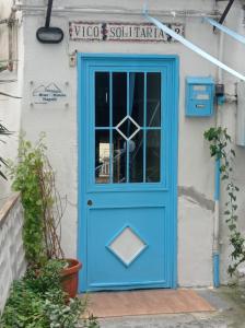 una puerta azul en el lateral de un edificio en Blue House Napoli, en Nápoles