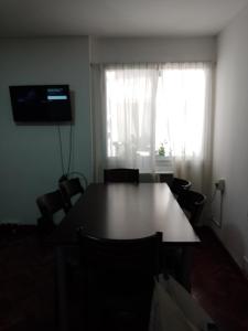 mesa y sillas en una habitación con ventana en Departamento en el Centro Histórico de Rosario en Rosario