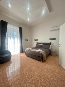um quarto com uma cama e uma grande janela em Casa Panorama, casa vacanza. em Torre del Greco