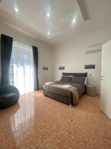 a bedroom with a bed and a large window at Casa Panorama, casa vacanza. in Torre del Greco