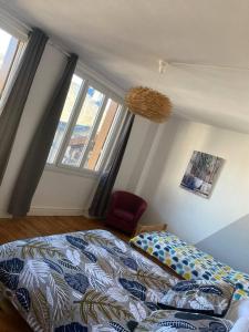 a bedroom with a bed and a large window at Gite de Tom et Mag classé 3 * Clevacances in Pontgibaud