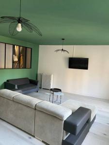 a living room with a couch and a tv at Gite de Tom et Mag classé 3 * Clevacances in Pontgibaud