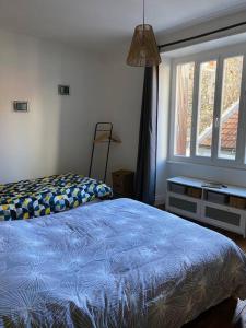 a bedroom with a blue bed and a window at Gite de Tom et Mag classé 3 * Clevacances in Pontgibaud