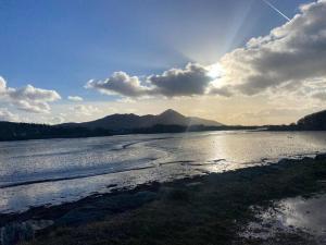 een uitzicht op een rivier met de zon die schijnt bij Modern apartment at Croagh Patrick in Westport