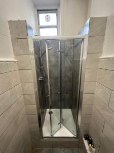 La salle de bains est pourvue d'une douche et d'une cabine de verre. dans l'établissement Thanet Hotel Annex, à Londres
