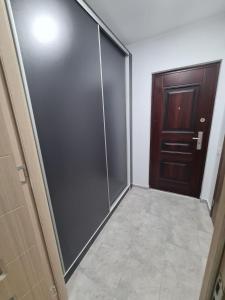 a bathroom with a sliding glass door next to a door at Garsoniera Luxury Lorena in Piteşti
