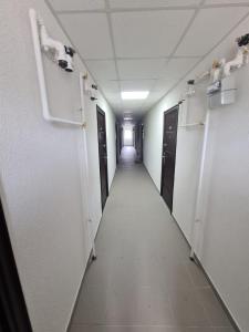 a corridor of a hallway with doors and a long hallway at Garsoniera Luxury Lorena in Piteşti