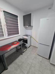 uma pequena cozinha com uma mesa e um frigorífico em Garsoniera Luxury Lorena em Piteşti