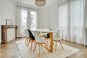 comedor con mesa y sillas en Maison familiale en plein centre ville à 20 min de Paris et Disney, en Saint-Maur-des-Fossés