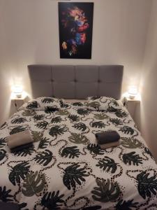 ein Bett mit einer schwarzen und weißen Bettdecke mit zwei Kissen in der Unterkunft Apartment Ivante in Kaštela