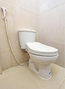 a toilet in a bathroom with a hose at SPOT ON 92549 Wisma Ribas Syariah 