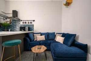 a living room with a blue couch and a kitchen at Vibrant Leith Flat in Edinburgh