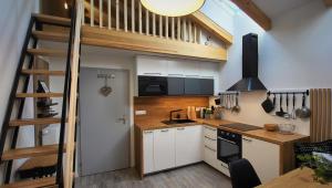 a kitchen with a staircase leading up to a loft at Loft Rezidence Vista in Rokytnice nad Jizerou