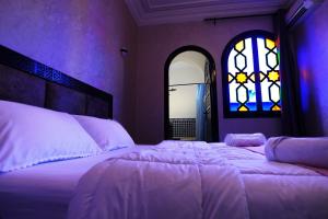 a bedroom with a large bed and a window at VILLA YOUSRA in Marrakech