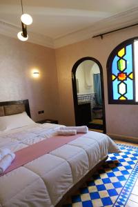 - une chambre avec un lit et un vitrail dans l'établissement VILLA YOUSRA, à Marrakech