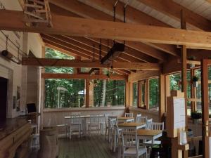 a dining room with tables and chairs and windows at Orme nel parco - Villaggio Grechi in Tirivolo