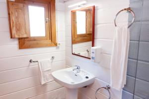 Baño blanco con lavabo y espejo en APARTAMENTOS PALASIET, en Benidorm