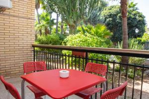 貝尼多姆的住宿－APARTAMENTOS PALASIET，阳台上的红色桌椅