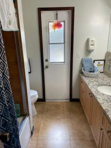 a bathroom with a toilet and a sink and a window at Cozy Guest House Florida, Tamarac in Tamarac