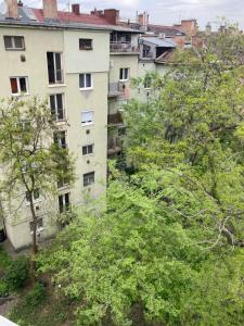 an apartment building with trees in front of it at Roland Apartment - PUSKAS in Budapest