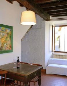 a living room with a table with a bottle of wine at Torrione Apartment in Panzano