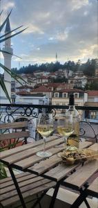 una mesa con 2 copas de vino en el balcón en Ivanoski Studios and Guest Rooms, en Ohrid