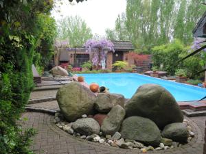 a swimming pool with rocks around a swimming pool at Ferienwohnung am Niederrhein in Kevelaer