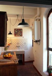 a kitchen with a bowl of fruit on a table at Torrione Apartment in Panzano