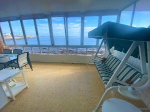 Cette chambre comprend des chaises et des tables et offre une vue sur l'océan. dans l'établissement Salinetas, frente al mar y playa, à Telde