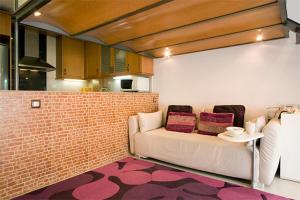a living room with a couch and a brick wall at Reina Amalia Apartment in Barcelona