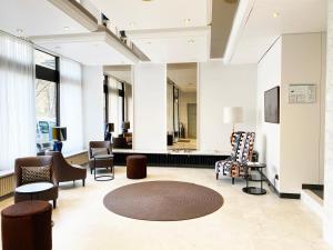 um átrio com cadeiras e uma sala de espera em domus Hotel em Munique