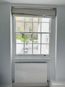 uma janela num quarto com vista para um edifício em Londwell, Luxe and Leaves, Chelsea Flat with Private Garden em Londres